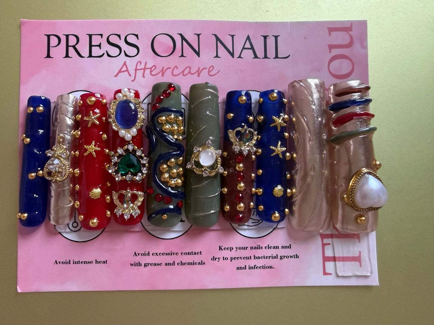 Bedazzled extra-long press-on nails with gold beads, pearls, and gemstones