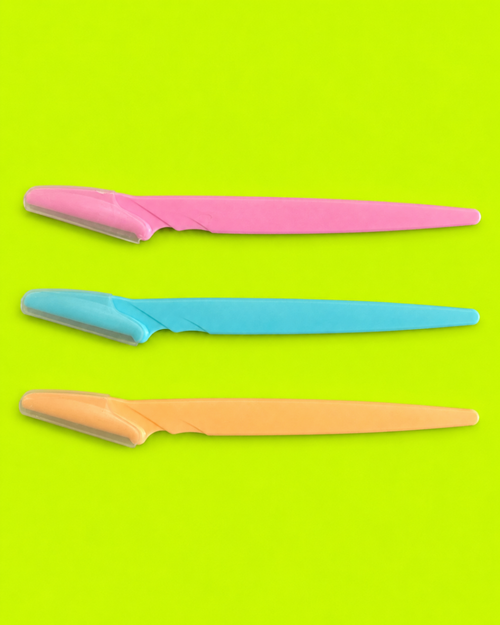 Pretty Sharp brow razors in pink blue and peach on neon green background